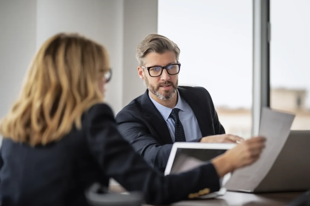 Aufnahme von zwei Geschäftsleuten, die im Besprechungsraum an einem Laptop arbeiten. Teamarbeit im Büro.
